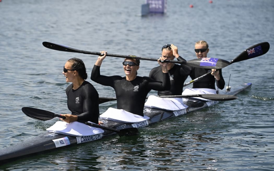 (L-R) New Zealand's gold medallists Lisa Carrington, Alicia Hoskin, Olivia Brett and Tara Vaughan celebrate their victory in the women's kayak four 500m final of the canoe sprint competition at Vaires-sur-Marne Nautical Stadium in Vaires-sur-Marne during the Paris 2024 Olympic Games on August 8, 2024. (Photo by Olivier MORIN / AFP)