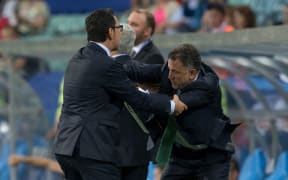 Juan Carlos Osorio restrained by officials during the match between Mexico and the All Whites.