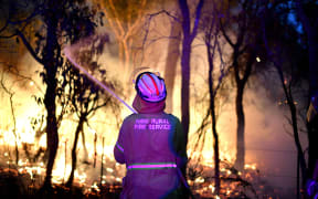 A firefighter protecting a residential area from bushfires north of Sydney on 7 December, 2019. Experts said the last Australian bushfire season arrived earlier and with more intensity because of climatic changes and prolonged drought.