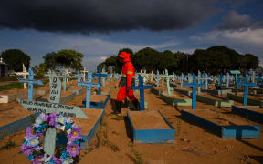 A gravedigger walks among graves of COVID-19 victims at the Nossa Senhora Aparecida cemetery in Manaus, Amazonas state, Brazil.