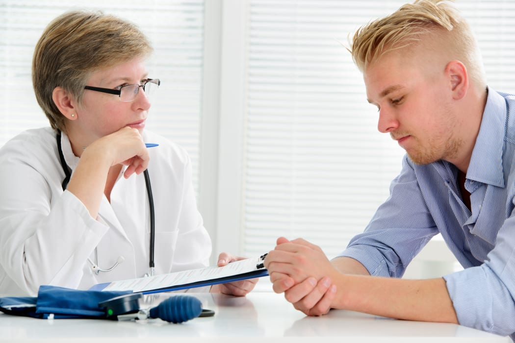 21647914 - doctor talking to her male patient at office