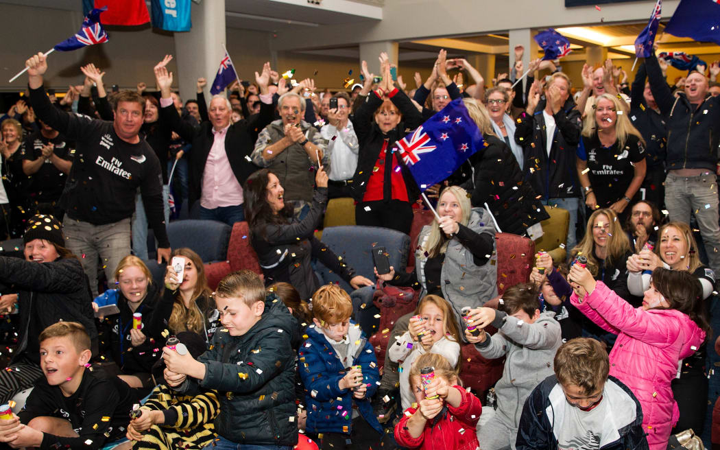 Members watch the America`s Cup match race between Team New Zealand and Oracle at the Royal New Zealand Yacht Squadron, in 2017.