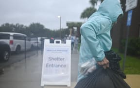 People arrive to shelter buffalo creek middle school ahead of Hurricane Milton expected landfall in Bradenton, Florida on October 9, 2024. - Milton regained power on October 8 to become a Category 5 storm with maximum sustained winds of 165 mph (270 kph) as it barrels towards the west-central coast of Florida and is forecast to make landfall late October 9, according to the National Hurricane Center. (Photo by Miguel J. Rodriguez Carrillo / AFP)