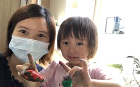 Lily Gao painting rocks with her 2yo daughter Elysse in the campervan.