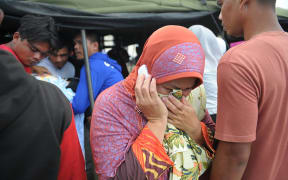 A woman grieves for her relative who died after an earthquake in Pidie Jaya, Aceh province on 7 December, 2016.