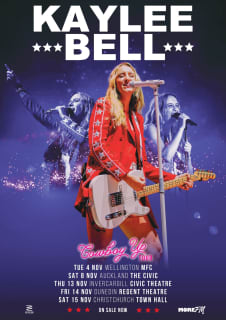 Kaylee Bell stands onstage with a guitar.