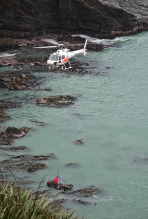 A police team at a remote cove in Southland are using a helicopter to lift a vehicle linked to a missing 11-year-old out of the sea.