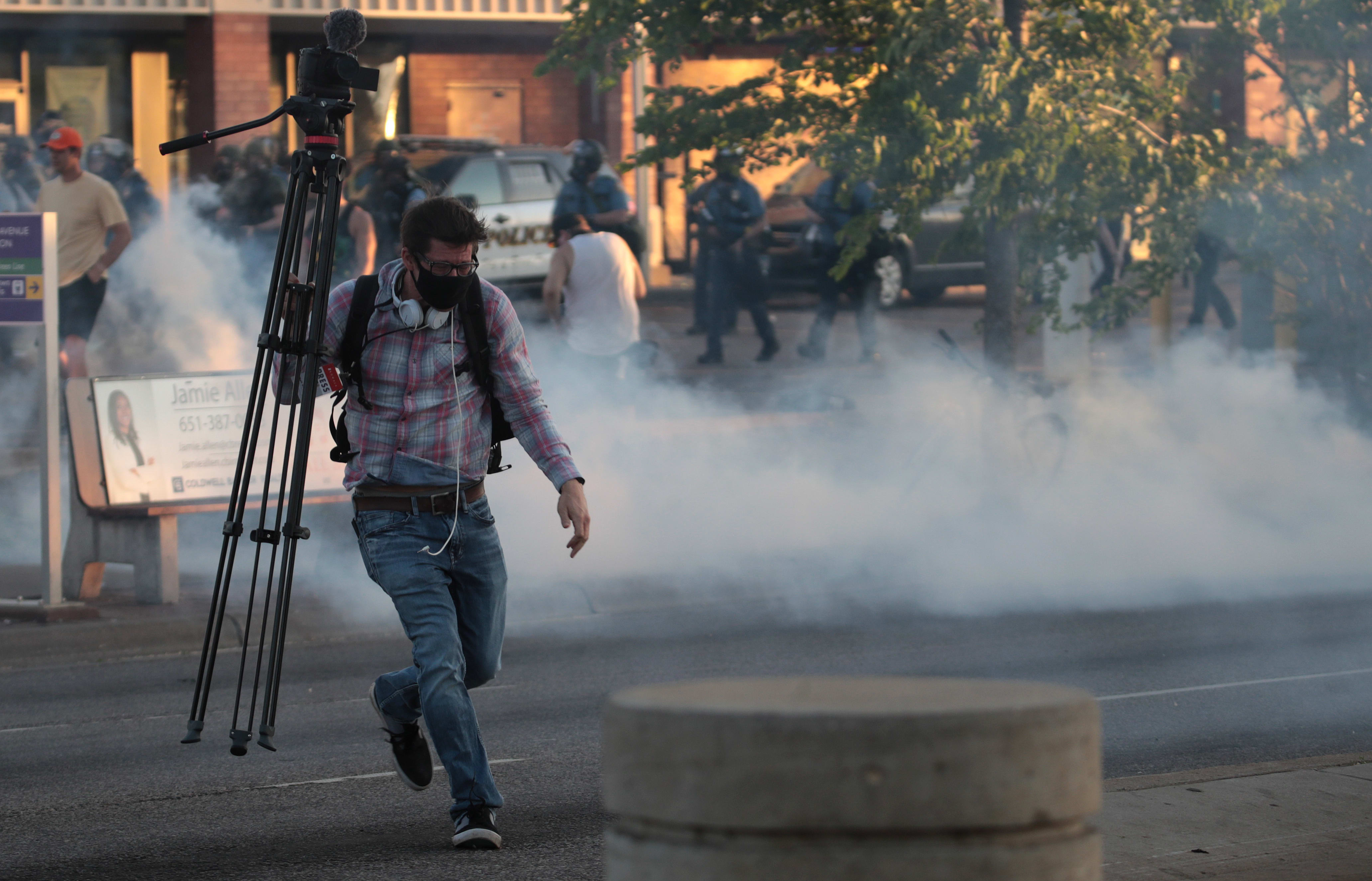 A member of the media runs through tear gas during a protest on May 28, 2020 in St. Paul, Minnesota.
