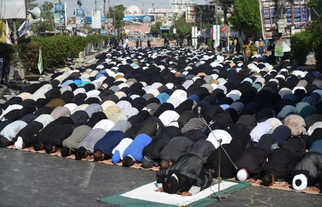 Pakistani Shiite Muslim devotees offer Friday prayers during the procession.