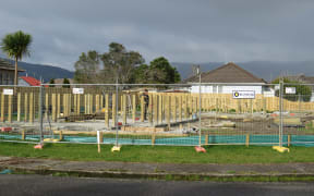 Piles 1.5m high are nearly as high as a worker on this site for two new Kāinga Ora homes in Westport. The home that used to occupy this site was demolished after being inundated in the 2021 floods. The new floor heights are a council requirement