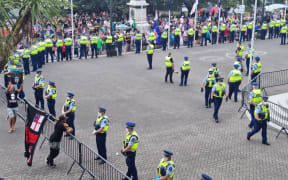 Police line the steel barriers around the protesters.