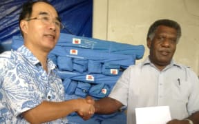 China's Ambassador in Vanuatu, Xie Bohau officially hands over Chinese relief to the Minister of Climate Change, James Bule.