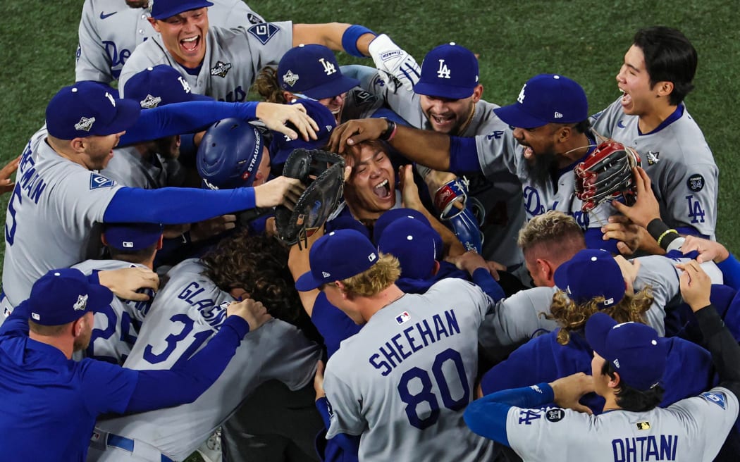 TORONTO, ONTARIO - NOVEMBER 02: Pitcher Yoshinobu Yamamoto #18 of the Los Angeles Dodgers (R) celebrates with teammates after defeating the Toronto Blue Jays, 5-4, in game seven of the 2025 World Series at Rogers Center on November 02, 2025 in Toronto, Ontario.   Patrick Smith/Getty Images/AFP (Photo by Patrick Smith / GETTY IMAGES NORTH AMERICA / Getty Images via AFP)