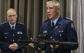 Senior Sergeant Paddy Hannon shows media a Norinco-5-point-56, a mock of the M16 rifle, which is now illegal.