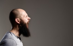 Side view portrait of screaming bearded man - gray background