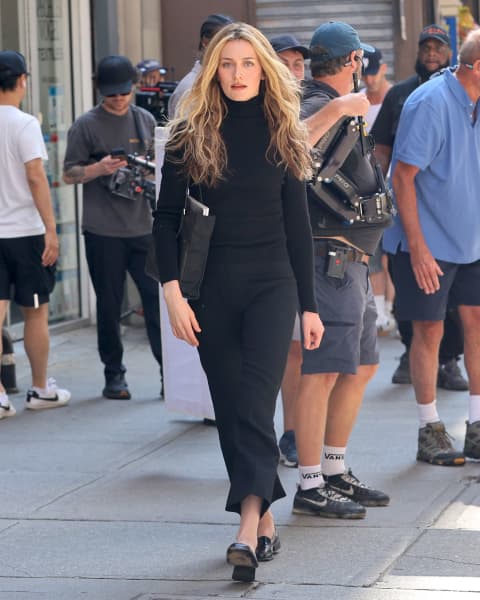 Sarah Pidgeon as Carolyn Bessette Kennedy walking on the street.