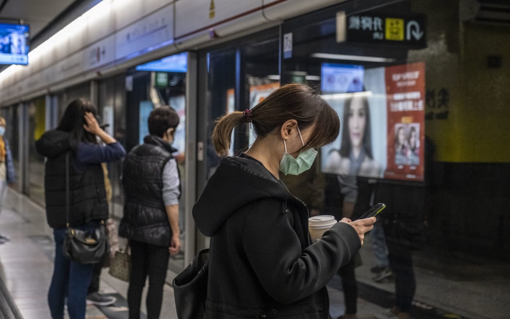 A woman wears a mask as she waits for an MTR Train on a platform in Tsim Sha Tusi on January 22, 2019 in Hong Kong, China.