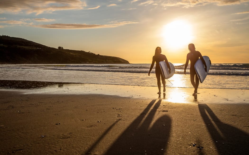Surfers on Ngarunui Beach, Waikato