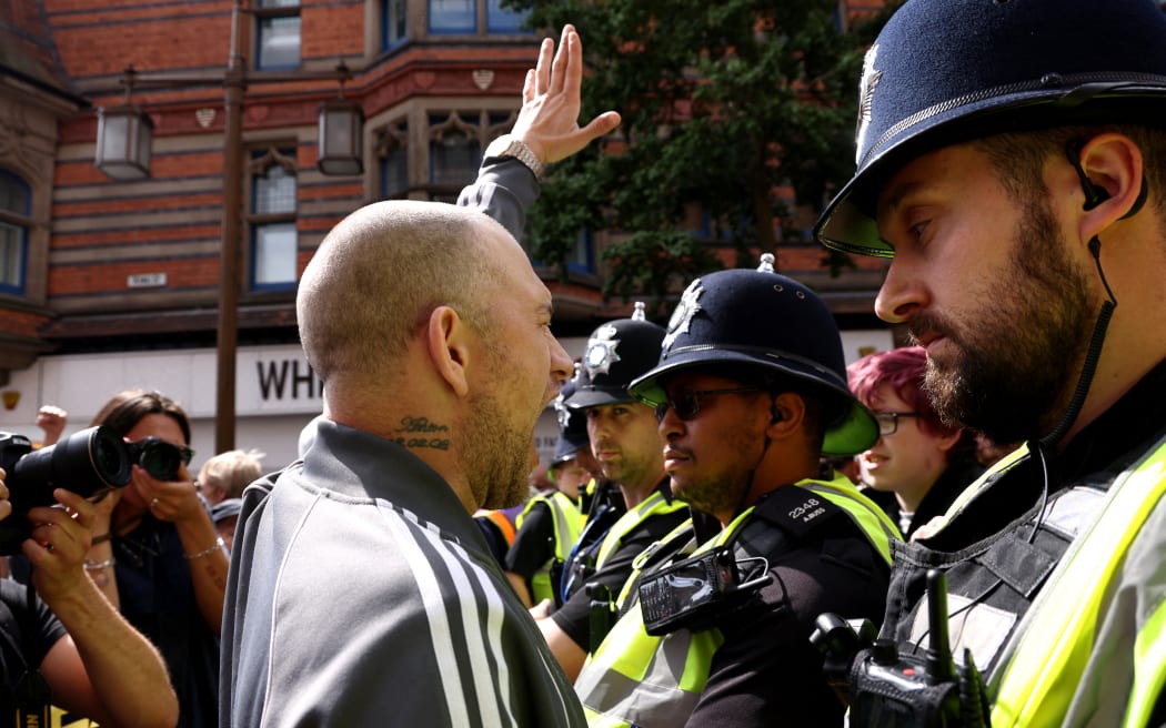 A protestor gestures at counter-protestors in Nottingham, central England, on 3 August, 2024 during the 'Enough is Enough' demonstration held in reaction to the fatal stabbings in Southport on 29 July. UK police prepared for planned far-right protests and other demonstrations, after two nights of unrest in several English towns and cities.