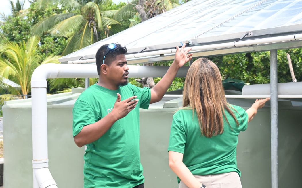 David Kakiakia shows ChildFund NZ programmes director Maria Trogolo solar water distillation equipment.