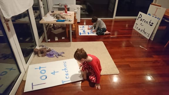 Marnie Wilton's children making signs to support Teachers' Mega strike.