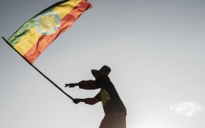 A man waves an Ethiopian flag as he join others gathering in Addis Ababa, Ethiopia, on 22 October, 2022 during a demonstration in support of Ethiopia armed forces.