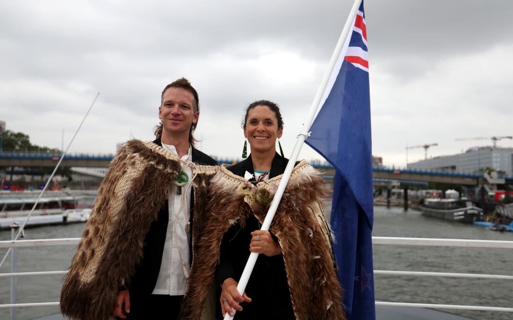 PARIS, FRANCE - JULY 26: Jo Aleh and Aaron Murray Gate, Flagbearers of Team New Zealand, pose for a photo while cruising during the athletes’ parade on the River Seine during the opening ceremony of the Olympic Games Paris 2024 on July 26, 2024 in Paris, France. (Photo by Hannah Peters / POOL / AFP)