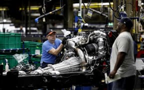 Line workers work on the chassis of full-size General Motors pickup trucks at the Flint Assembly plant on June 12, 2019 in Flint, Michigan.