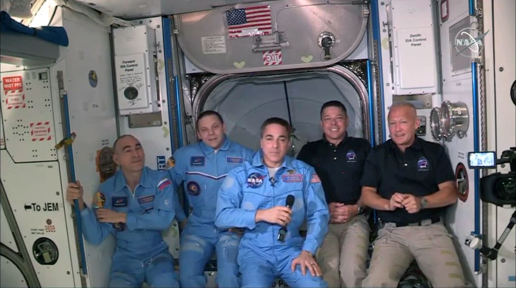 NASA astronauts Doug Hurley (R) and Bob Behnken (2R) join NASA astronaut Chris Cassidy (C) and Russian cosmonauts, Anatoly Ivanishin (L) and Ivan Vagner (2L) aboard the International Space Station after successfully docking SpaceX's Dragon capsule May 31, 2020.
