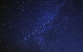 A meteor burns up in the sky over al-Abrak desert north of Kuwait City during the annual Geminid meteor shower early on 15 December, 2023.