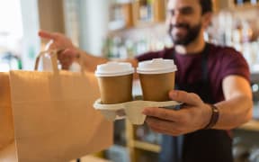 small business, people and service concept - man or bartender serving customer at coffee shop