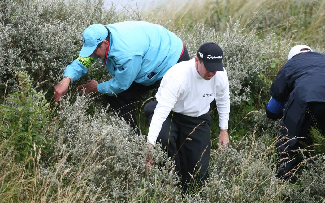 Australian golfer Rod Pampling looks for lost golf ball.