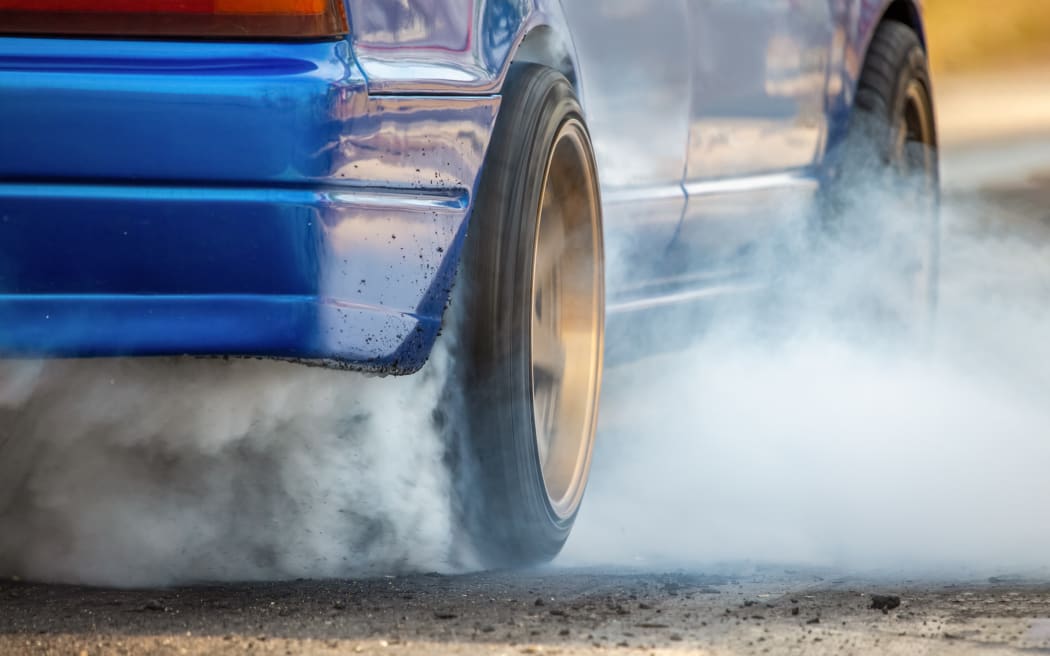 Stock image. Drag racing car burns rubber off its tires in preparation for the race