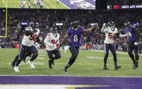 Lamar Jackson #8 of the Baltimore Ravens scores a touchdown during an NFL Divisional Round playoff game against the Houston Texans at M&T Bank Stadium.