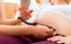 A file photo shows a midwife with a pregnant woman.