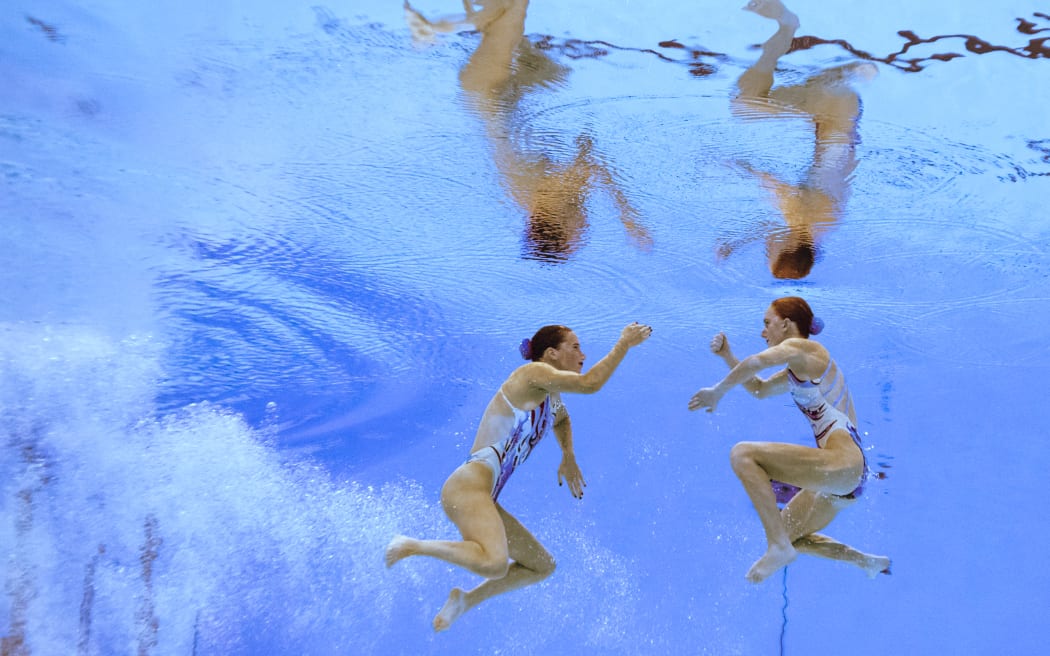 New Zealand's Nina Brown and Eva Morris compete in the preliminary round of the women's duet free artistic swimming event during the 2024 World Aquatics Championships in Doha.