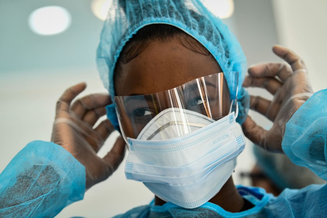 A medical worker adjusts her protective face mask at a medical centre in Paris.