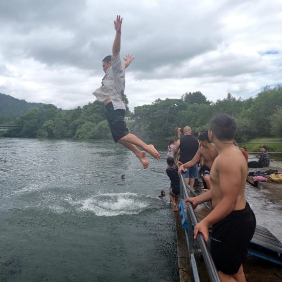 Rangatahi cooling off in the Waikato River next to Tūrangawaewae Marae during the hui-ā-motu called by the Māori King.