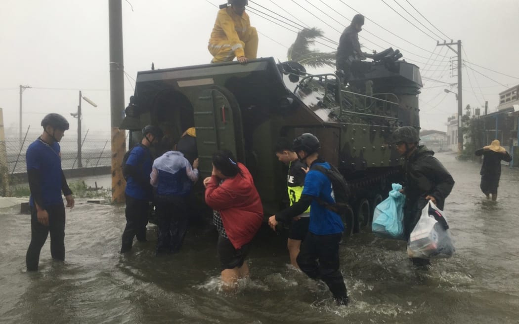 Locals affected by super typhoon Meranti are evacuated on a military armoured vehicle in southern Pingtung county in Taiwan.