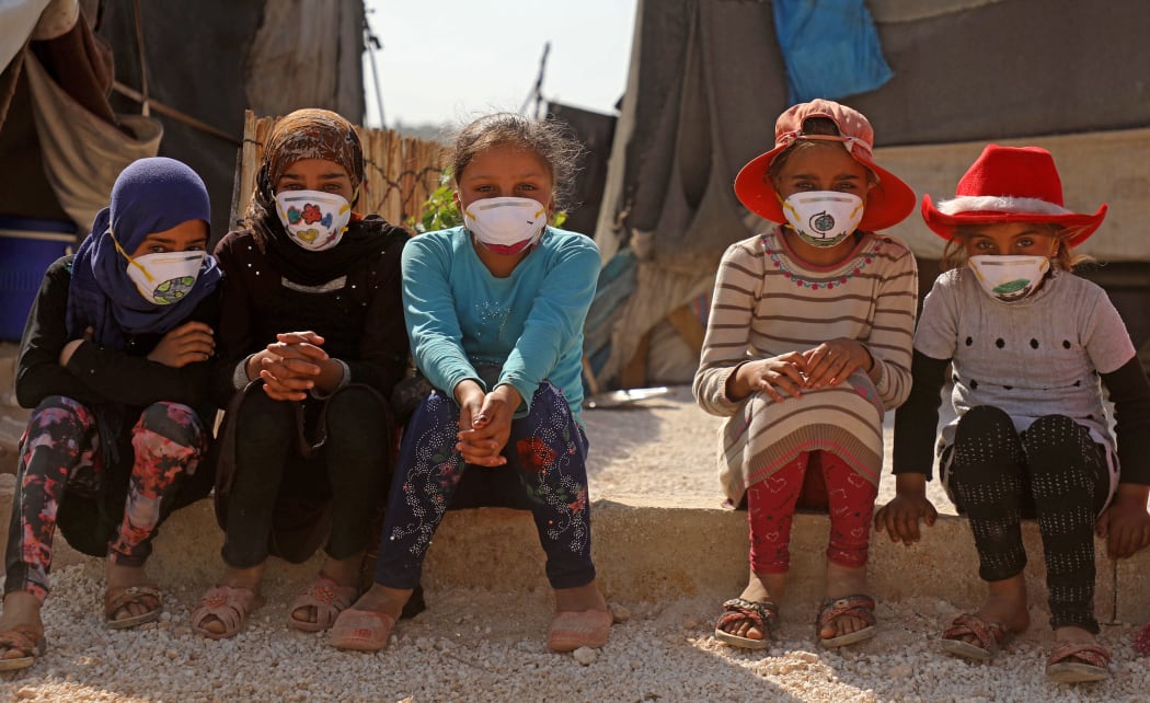Displaced Syrian girls wear face masks decorated by artists during a COVID-19 awareness campaign at the Bardaqli camp in the town of Dana in Syria's northwestern Idlib province, on April 20, 2020.