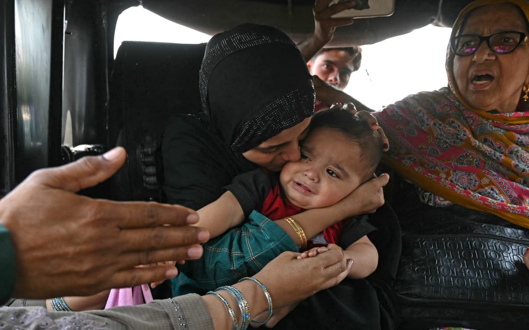 A Pakistani citizen (L) kisses goodbye to her son, an Indian citizen, as she prepares to return to her country through the India-Pakistan Wagah border post, about 35kms from Amritsar on April 29, 2025. Indian and Pakistani soldiers exchanged gunfire in disputed Kashmir for a fifth straight night, New Delhi's army said on April 29, one week since an attack targeting tourists sent relations into a tailspin. After the April 22 attack, New Delhi downgraded diplomatic ties, withdrew visas for Pakistanis, suspended a water-sharing treaty, and announced the closure of the main land border crossing with Pakistan. (Photo by Narinder NANU / AFP)