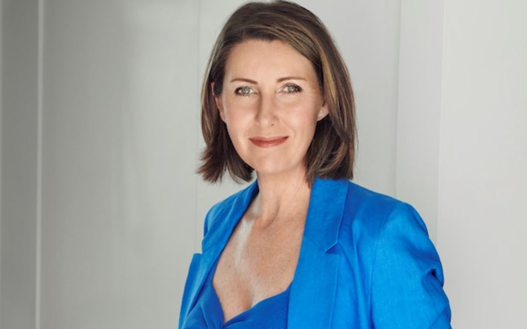 Niki Bezzant smiles at the camera wearing a sky blue blazer, top and trousers.