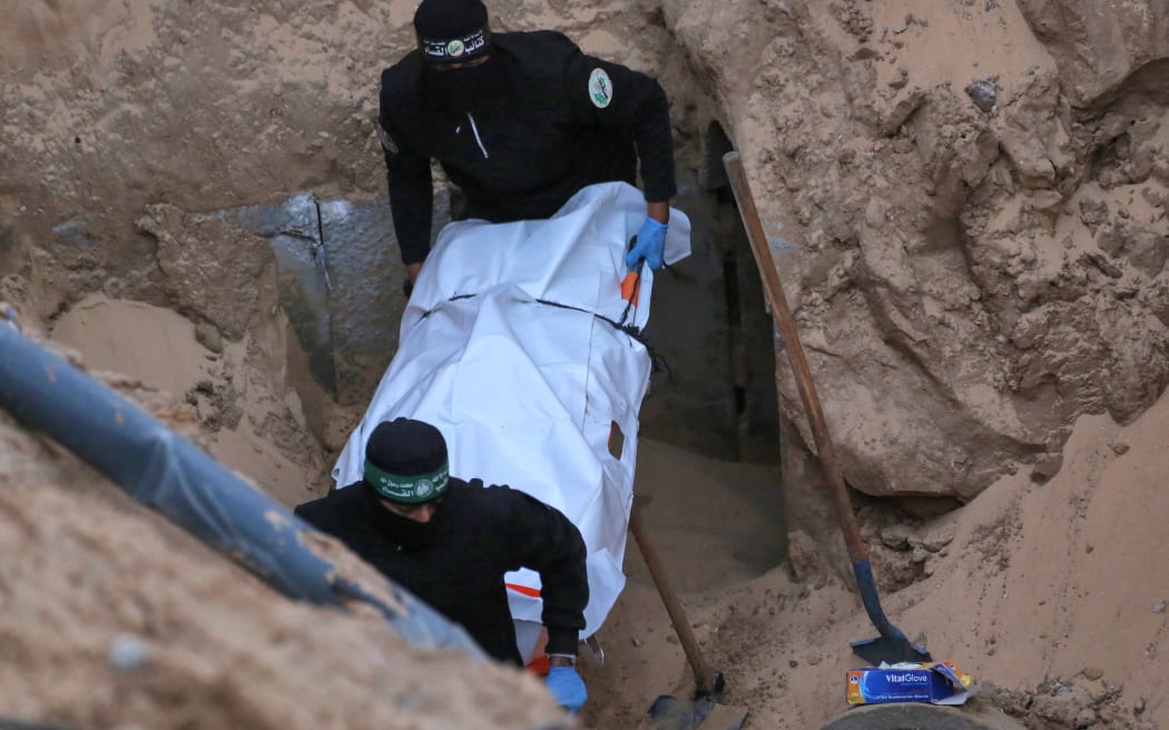 Hamas militants carry a body retrieved from a tunnel in an area north of Khan Yunis in the southern Gaza Strip on 28 October, 2025.