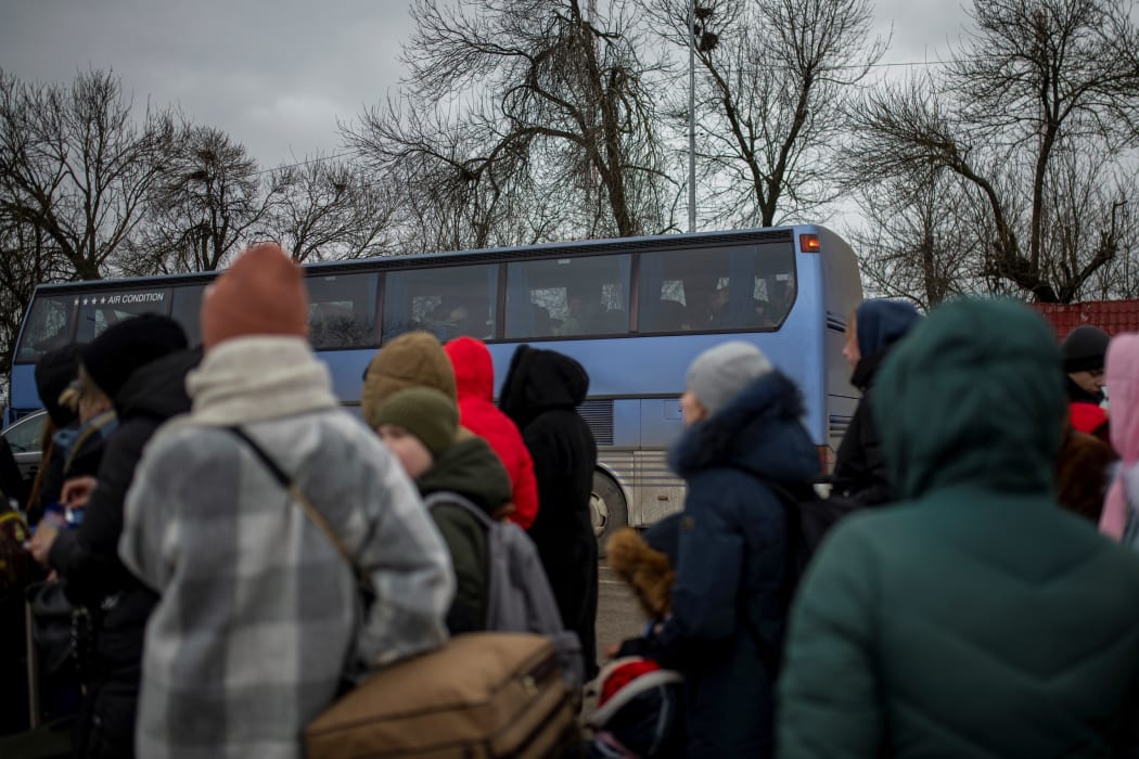 Several people and children wait to cross into Romania at the Porubne border crossing on March 5, 2022, in western Ukraine. According to the latest information, Ukraine suspended today the evacuation of civilians from Mariupol after Russia broke the ceasefire to open humanitarian corridors.