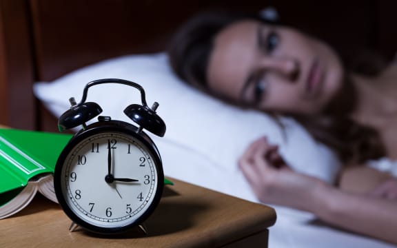 Alarm clock on night table showing 3 a.m.