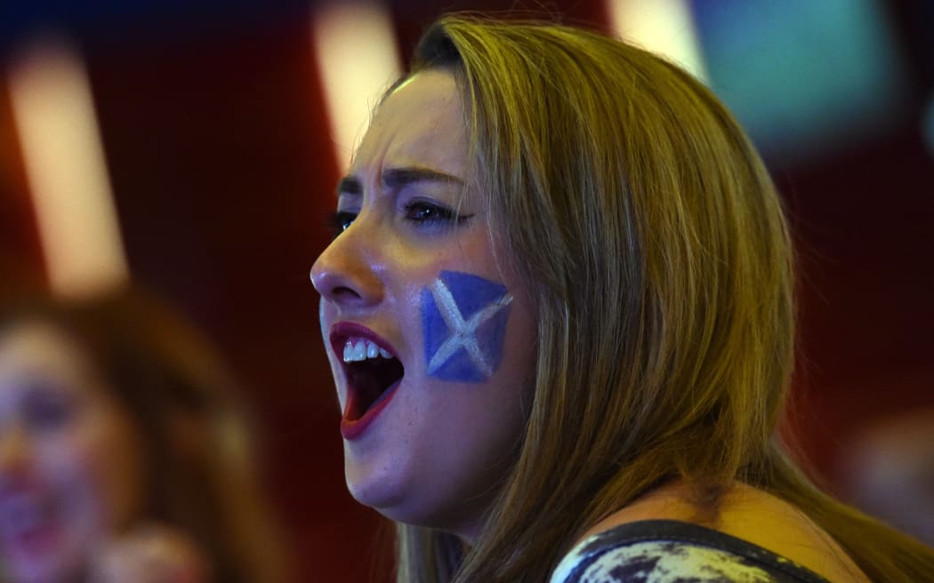 A Scottish rugby fan reacts in a Sydney bar on October 19, 2015, as Australia narrowly defeat Scotland in their Rugby World Cup quarter-final match played in England. AFP PHOTO/William WEST