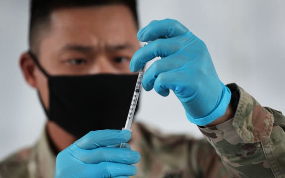 NORTH MIAMI, FLORIDA - MARCH 09: A U.S. Army soldier from the 2nd Armored Brigade Combat Team, 1st Infantry Division, prepares Pfizer COVID-19 vaccines to inoculate people at the Miami Dade College North Campus on March 09, 2021 in North Miami, Florida.