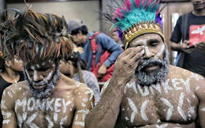 Wearing traditional headdress, Papuan human rights activists Ambrosius Mulait (left) and Dano Tabuni at the start of their trial in the Central Jakarta District Court