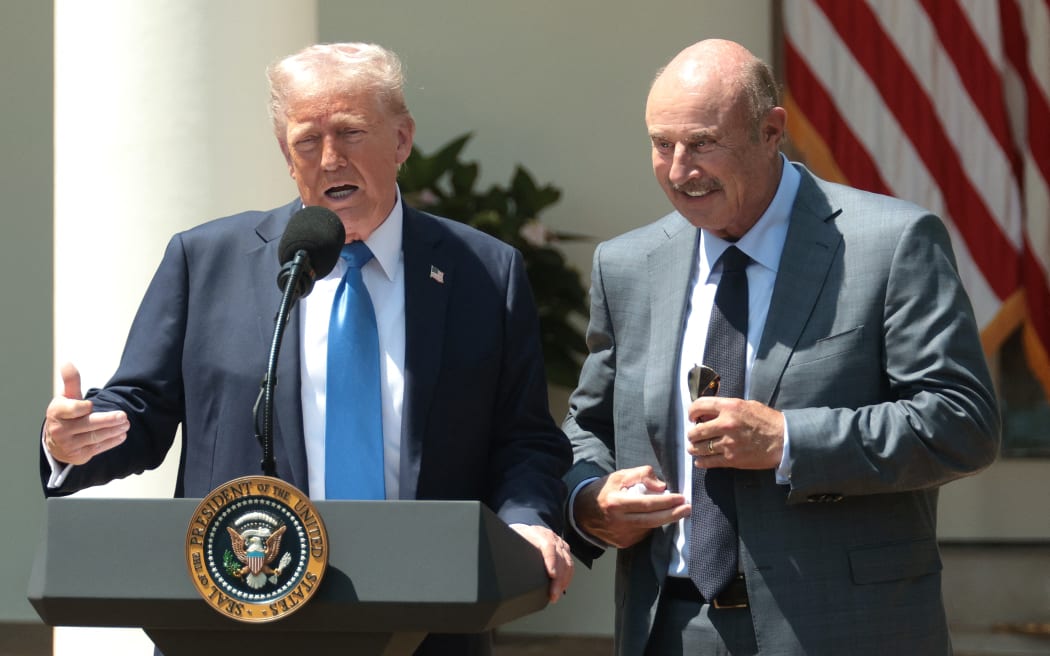 WASHINGTON, DC - MAY 01: U.S. President Donald Trump (L) speaks alongside Dr. Phil McGraw during a National Day of Prayer event in the Rose Garden at the White House on May 1, 2025 in Washington, DC. The National Day of Prayer is a congressionally recognized observance that calls on people of all faiths to participate in a day of prayer and reflection.   Alex Wong/Getty Images/AFP (Photo by ALEX WONG / GETTY IMAGES NORTH AMERICA / Getty Images via AFP)