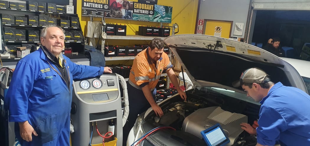 Roger Devlin, left, Aaron Williams and Hayden Foote working on the air conditioning on a Lexus Hybrid.